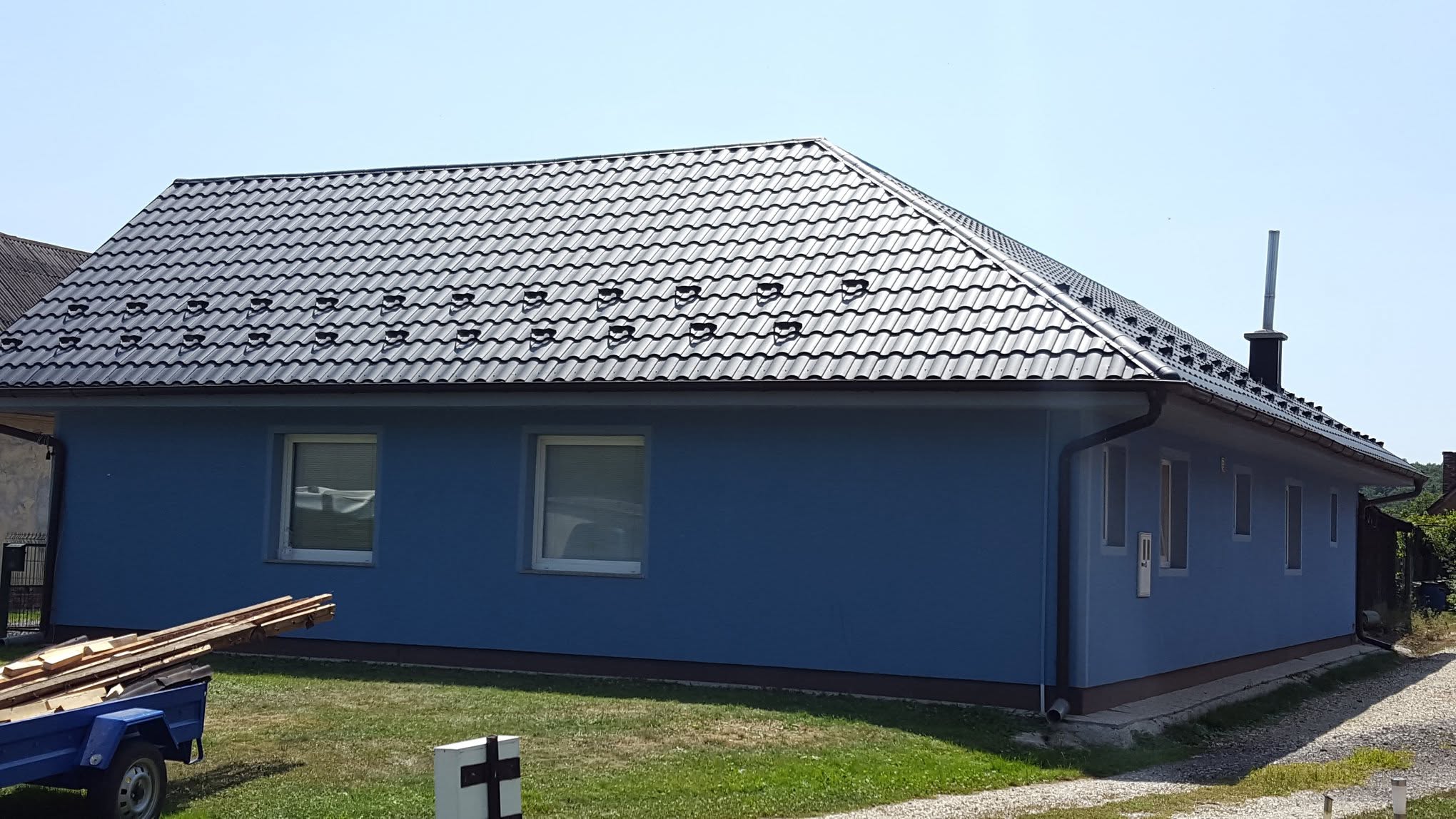 Antracitna kovinska kritina s snegobrani na pritlični hiši s štirikapno streho