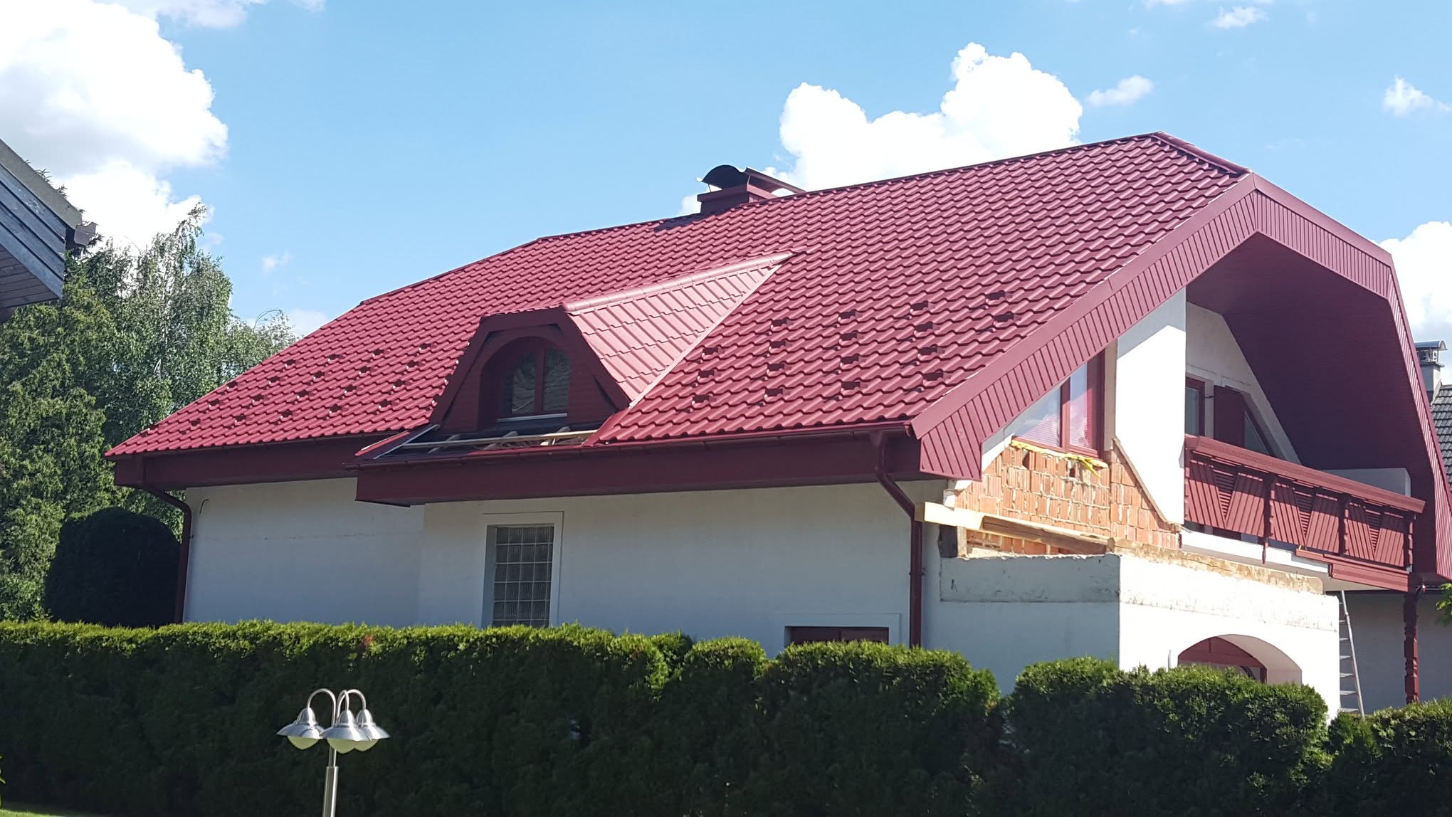 Rdeča kovinska kritina s frčado in obrobami na stanovanjski hiši